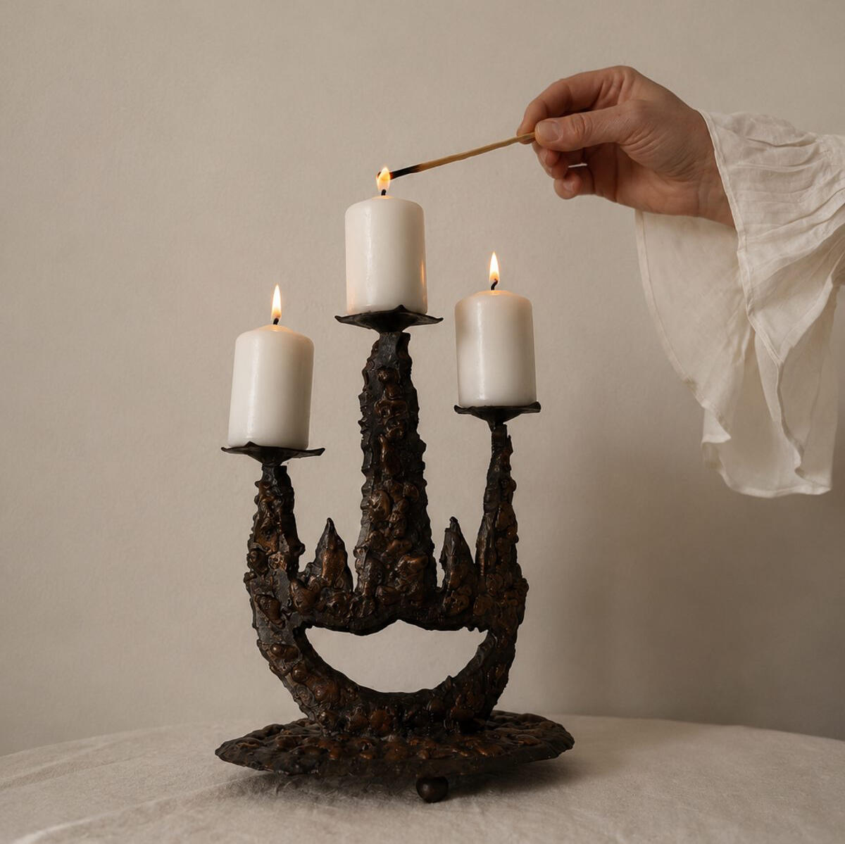 Editorial still life featuring a brutalist vintage candelabra with lit candles, photographed in soft natural light for The Malenca journal.