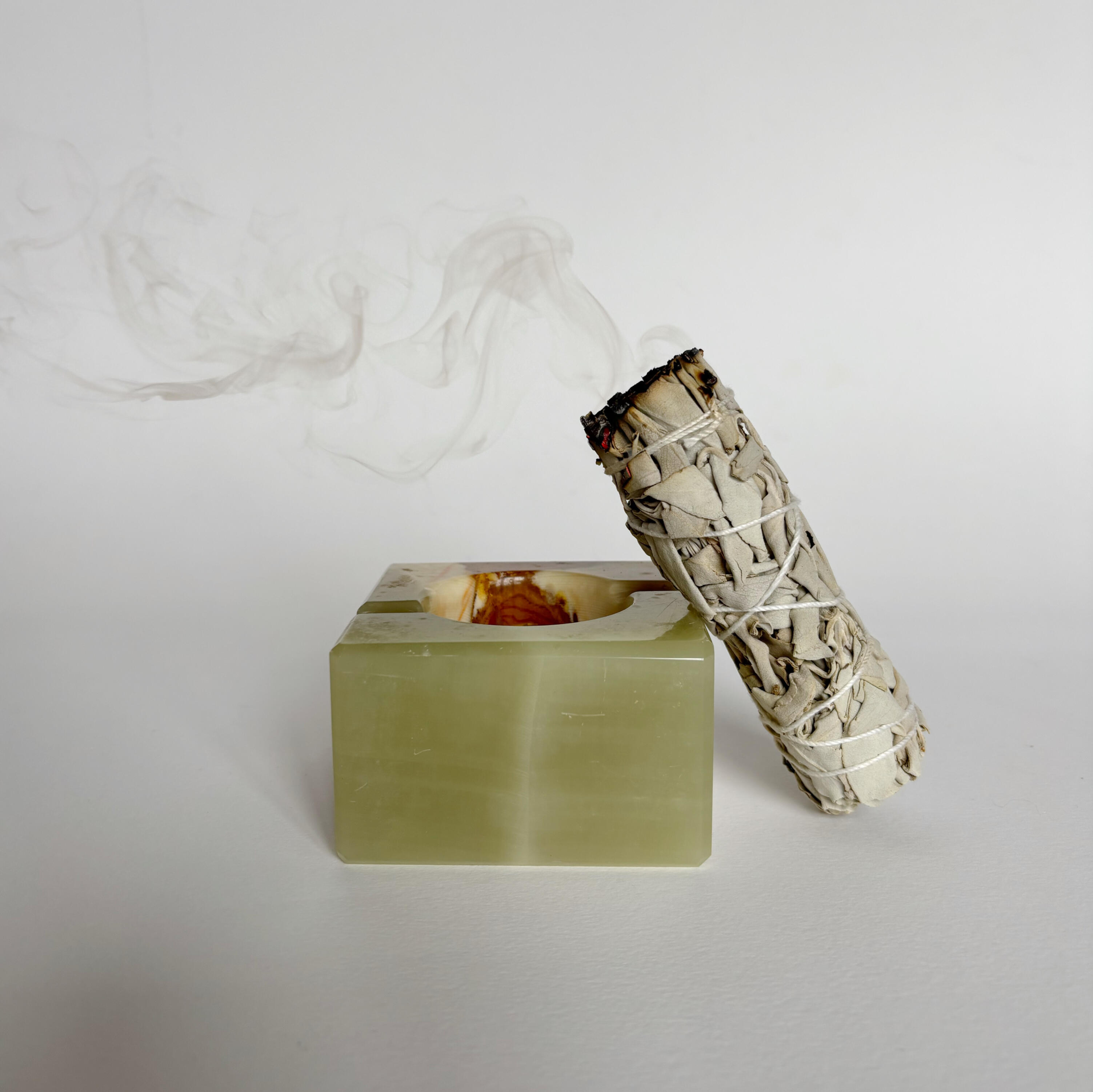 Vintage Onyx Ashtray sage stick resting on a green stone holder with soft smoke